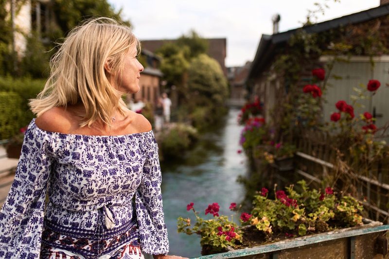 Alexia Bylett looking along a flower-lined river