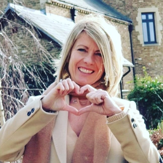 Alexia Bylett smiling and making a heart shape with her hands