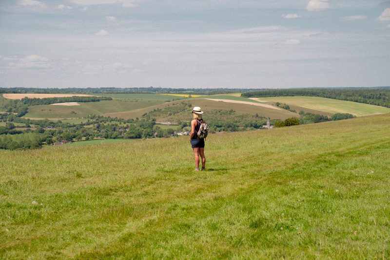 Alexia standing on a grassy hillside looking across the countryside